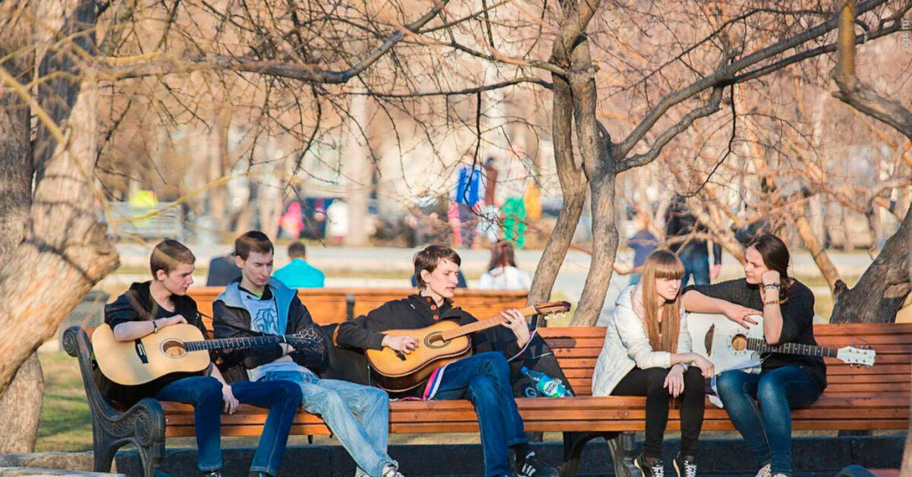Дети играют и поют в весеннем парке.